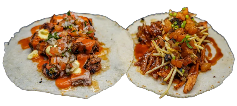 Dois tacos em tortilha de milho, um de frango churrasco com pico de gallo e outro de costela texana com batata palha.